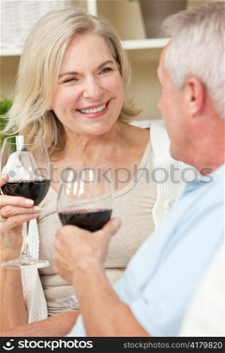 Happy Senior Man & Woman Couple Drinking Wine at Home