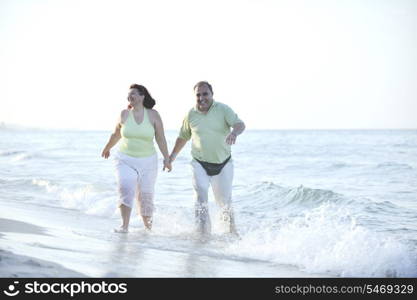 happy senior mature elderly people couple have romantic time on beach at sunset