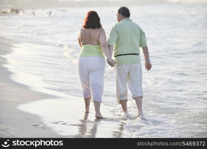 happy senior mature elderly people couple have romantic time on beach at sunset