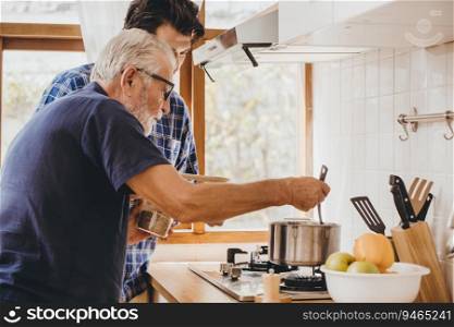 Happy senior old man enjoy teach cooking with his son at the kitchen room for stay at home leisure activity and lifestyle of people.