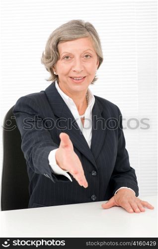 Happy senior successful businesswoman giving handshake close deal