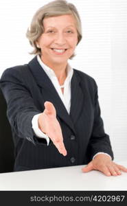 Happy senior successful businesswoman giving handshake close deal