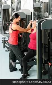 Happy senior woman at gym workout with personal trainer assistance