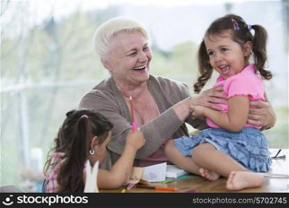 Happy senior woman having quality time with granddaughters at home