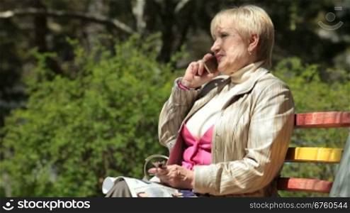 Happy senior woman talking on cellphone outdoors