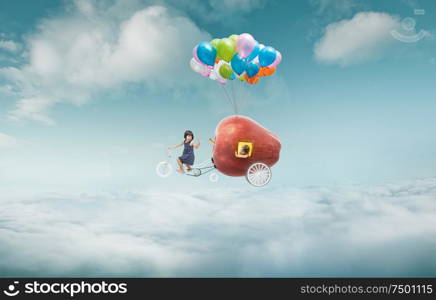 Happy sister enjoy with fantasy apple cycle ride and floating in sky with bunch of colorful balloons .