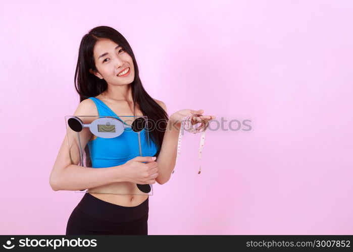 happy slim woman holding a weight scale