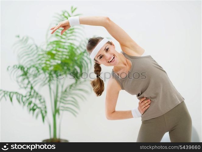 Happy slim woman making stretching exercises