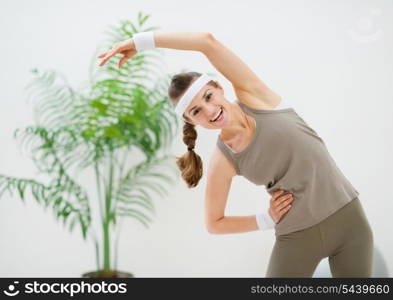 Happy slim woman making stretching exercises
