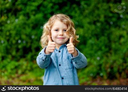 Happy small child with long blond hair and saying OK. Happy small child with long blond hair enjoying the nature and saying OK