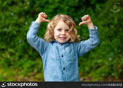 Happy small child with long blond hair and saying OK. Happy small child with long blond hair enjoying the nature and saying OK