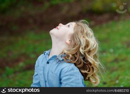 Happy small child with long blond hair enjoying the nature