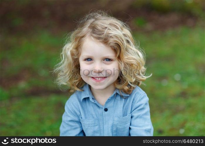 Happy small child with long blond hair enjoying the nature