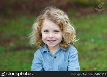 Happy small child with long blond hair enjoying the nature