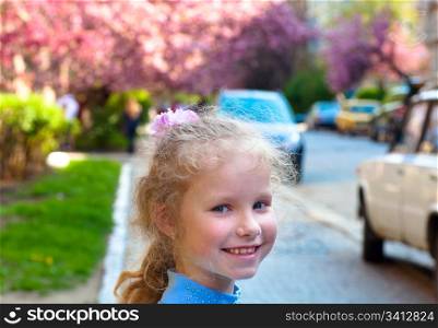 Happy small girl portrait and blossoming pink japanese cherry tree (Uzhgorod City, Ukraine)