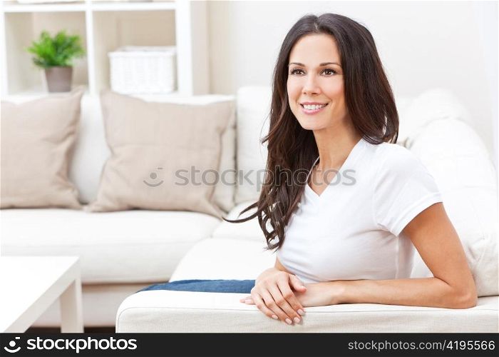 Happy Smiling Beautiful Woman Sitting on Sofa
