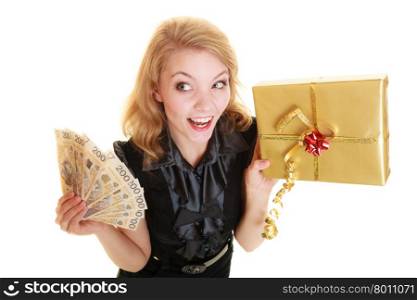 Happy smiling blonde girl young woman holding golden christmas gift box and polish currency money banknote. Holidays time for gifts.