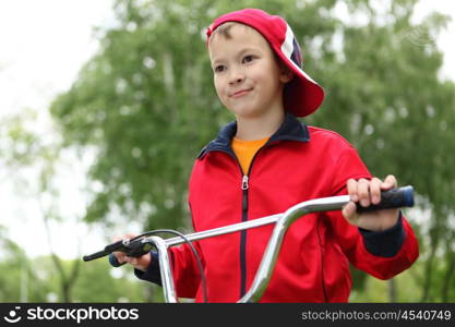 Happy smiling boy on a bicycle in the green park