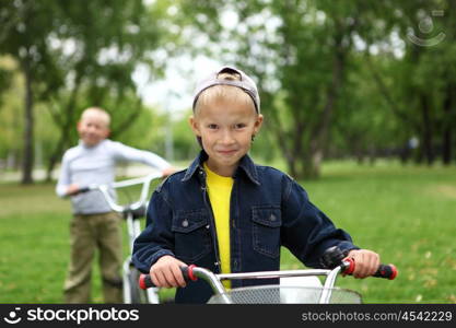 Happy smiling boy on a bicycle in the green park