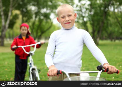 Happy smiling boy on a bicycle in the green park