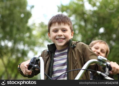 Happy smiling boy on a bicycle in the green park