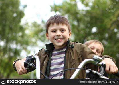 Happy smiling boy on a bicycle in the green park