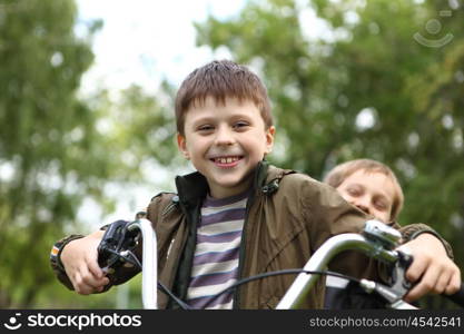 Happy smiling boy on a bicycle in the green park