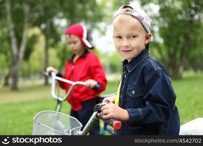 Happy smiling boy on a bicycle in the green park