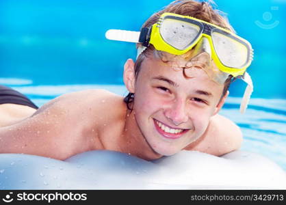 Happy smiling boy swimming in a pool