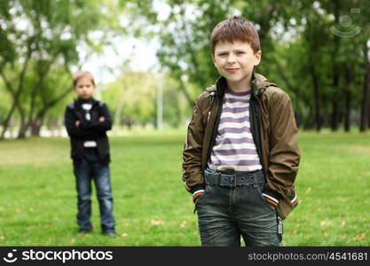 Happy smiling boy with a friend in the green park