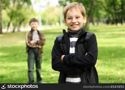 Happy smiling boy with a friend in the green park
