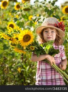 Happy smiling child with bunch of sunflowers in spring field