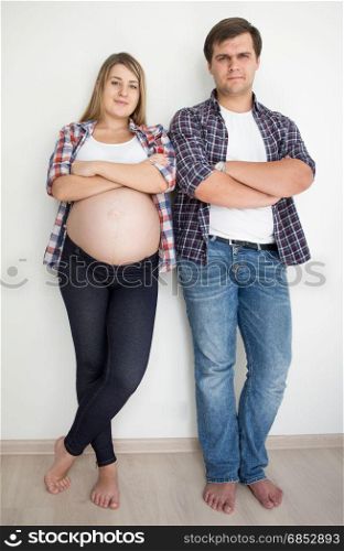 Happy smiling couple waiting for baby posing in jeans and shirts