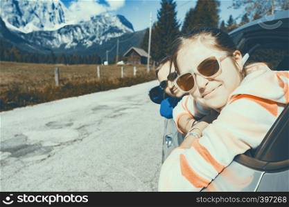 happy smiling dad and daughter looking out the car window and mountains in the background. Dolomites, Italy