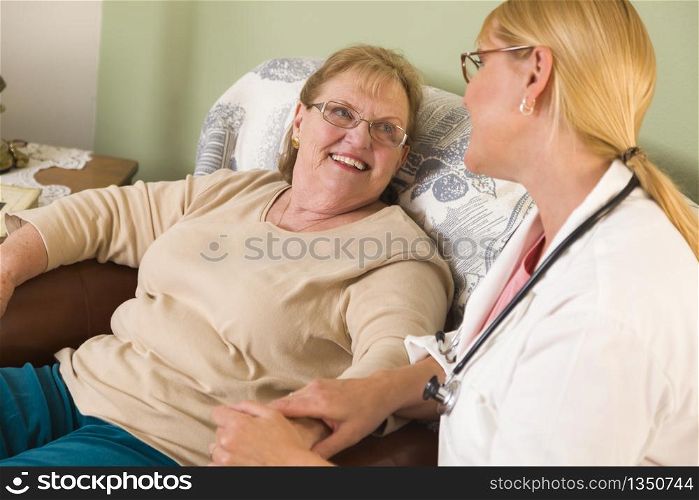 Happy Smiling Doctor or Nurse Talking to Senior Woman in Chair.