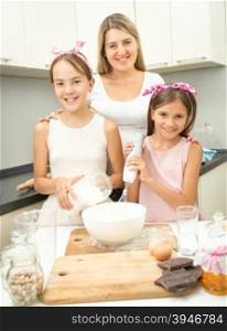 Happy smiling family making dough for pie on kitchen
