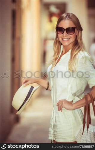 Happy smiling girl after shopping with pleasure walking city streets, cheerful woman enjoying her purchase, beautiful stylish female