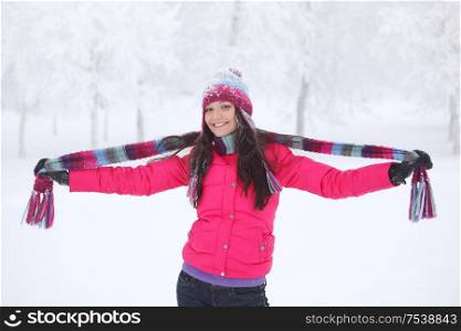 Happy smiling girl in pink clothes having fun in winter park. Happy girl in winter park