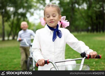 Happy smiling girl on a bicycle in the green park