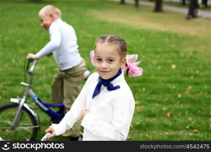 Happy smiling girl on a bicycle in the green park