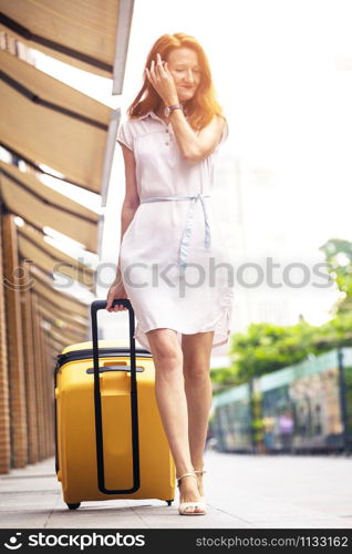 happy smiling girl traveler and her yellow luggage. wonderful travel