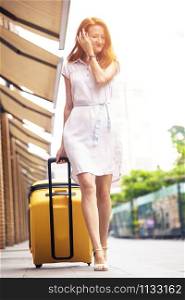 happy smiling girl traveler and her yellow luggage. wonderful travel