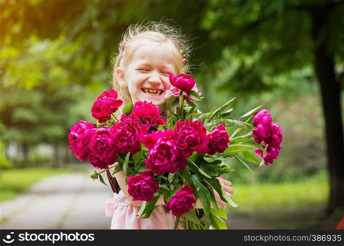 Happy smiling girl with a bouquet of pions, spring