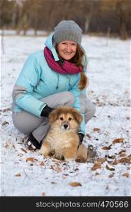 happy smiling girl with the dog corgi fluffy walking outdoors