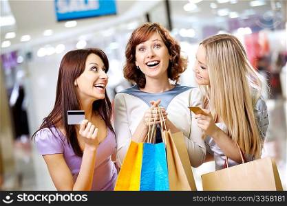 Happy smiling girls with credit cards in shop