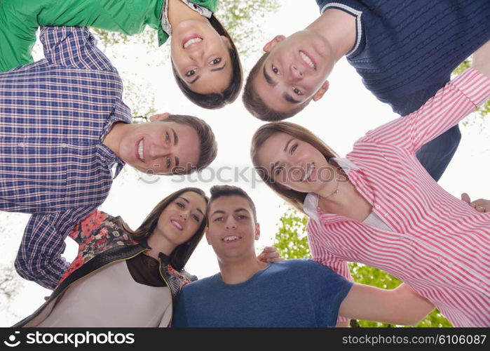 Happy smiling group of young friends staying together outdoor in the park