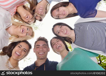 Happy smiling group of young friends staying together outdoor in the park