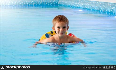 Happy smiling little boy swimming in indoor swimming pool. Happy smiling little boy swimming in indoor swimming pool.