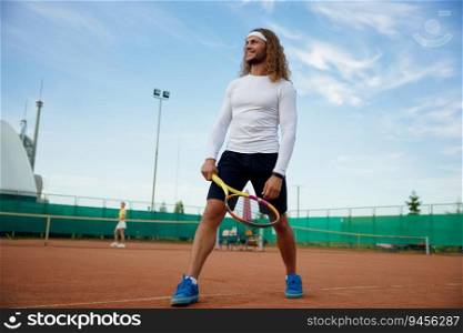 Happy smiling male tennis player wearing trendy outfit ready for morning workout on outdoor court. Happy smiling male tennis player ready for morning workout on outdoor court