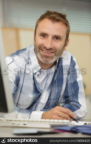 happy smiling man looking at the computer